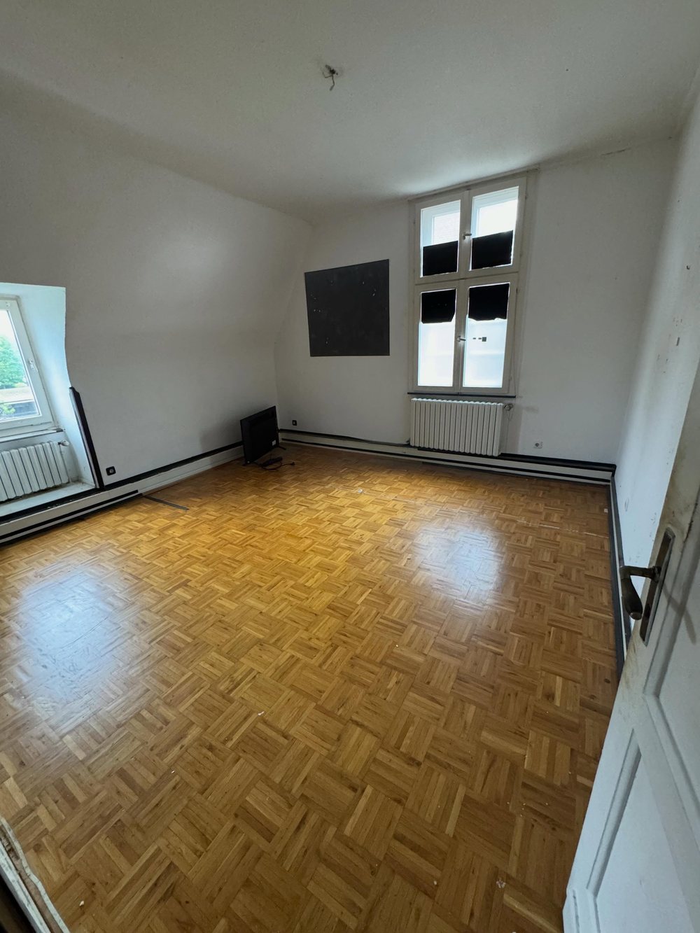 Nachher: leer geräumtes Zimmer mit Parkettboden, besenrein