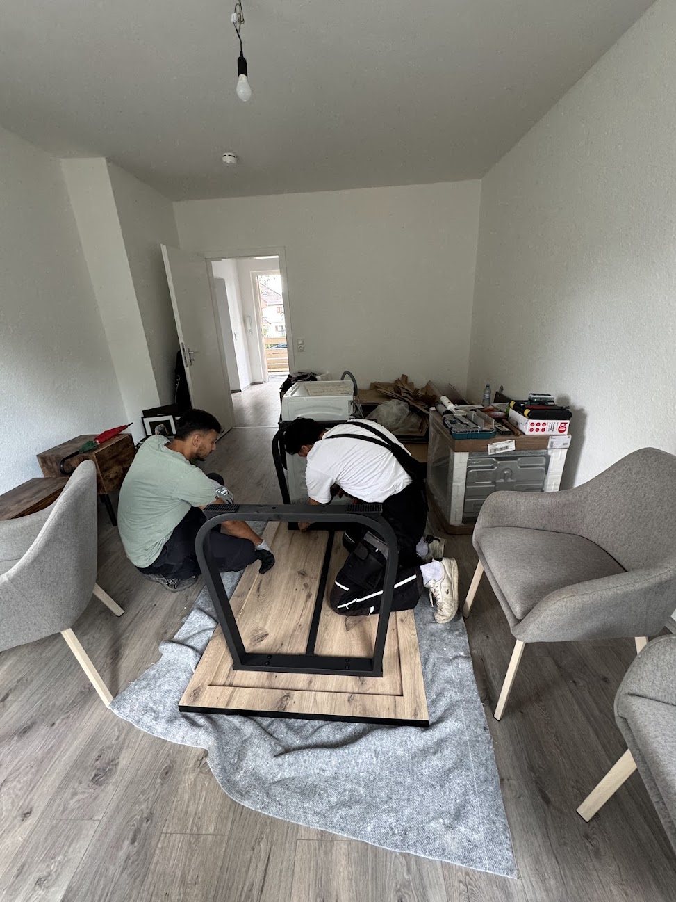 Zwei Mitarbeiter von Robins bauen in einer neuen Wohnung einen Esstisch auf